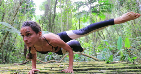 Naklejka na ściany i meble Athletic strong woman training yoga pose outdoors