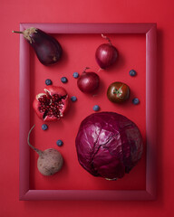 Red fruits and vegetables in wooden picture frame