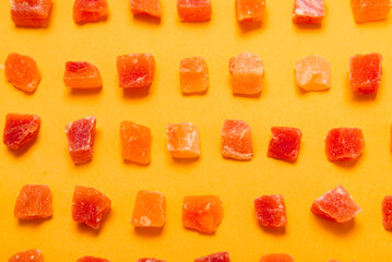 Candied fruits pineapple and papaya on yellow background