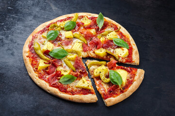 Traditional Italian pizza Hawaii with ham, pineapple and mozzarella served as close-up on an old rustic board with text free space