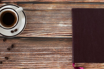 Holy Bible book and a cup of coffee on wooden background with copy space. Top table view.