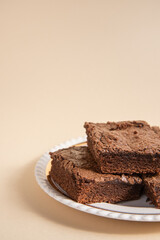 vertical photo of four brownies on a white dish