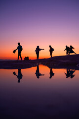 Fototapeta na wymiar A fun family by the lake at sunset, reflection and silhouette, golden hours, Pamukkale travertines - Denizli