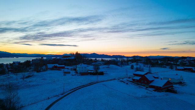 Sunset over the snow covered town center of Os&oslash;yro, Bj&oslash;rnafjorden, Norway
