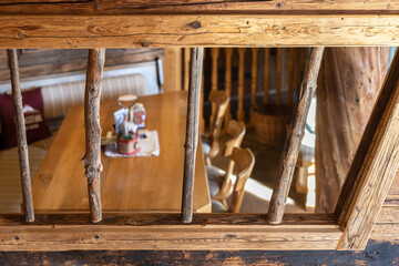 View of a cozy corner with a table and chairs through a wooden lattice in an alpine restaurant, Austria, Salzburg
