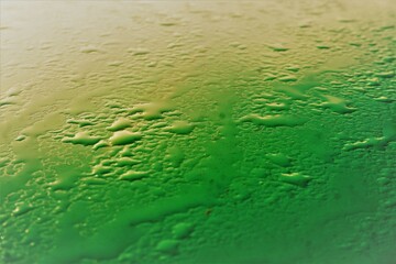 Grüne Metallfläche mit Wassermuster bei Sonne, Frost und Eis im Winter