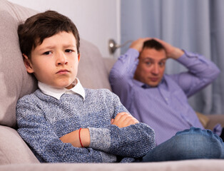 Portrait of offended tweenager after disagreements with his father at home ..