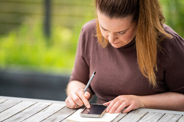 woman on her phone writing notes in australia