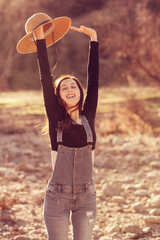 Country girl holding hat over her head