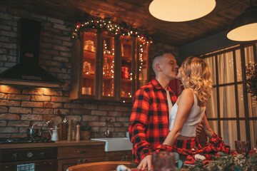 Fototapeta na wymiar Candid authentic happy married couple spends time alone at lodge Xmas decorated