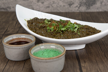 Traditional Indian meal consisting of a bowl of lamb saag and humus dipping sauce for extra flavor