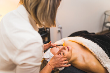 Obraz na płótnie Canvas A woman getting a facial massage in a spa beauty salon. High quality photo