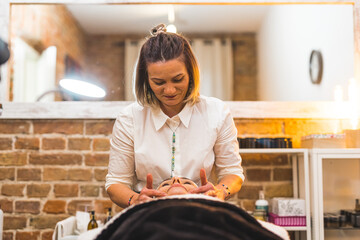 Professional beautician doing a facial skin massage to a woman in a spa salon. High quality photo