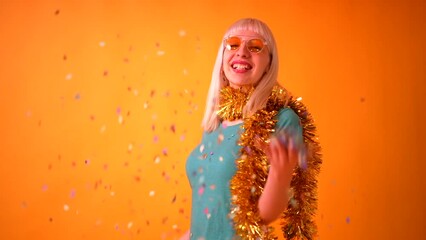smiling party with confetti at a celebration, blonde caucasian girl in studio on yellow background - Powered by Adobe