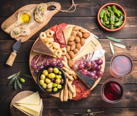 Appetizers boards with assorted  delicatessen cheese, salami, grape and nuts. Charcuterie and cheese platter, Spanish style and ingredients: olives, Pimientos, Chorizo, picos, cheese Semicurado - obrazy, fototapety, plakaty
