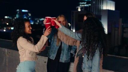 Friends, cheers and party at night in the city for celebration, party or event drinking in friendship in the outdoors. Happy women toasting drink celebrating new year, festive season or night life