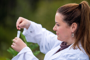 woman scientist taking soil samples and plant samples from a field