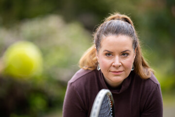 female tennis player practicing forehands and hitting tennis balls on a grass court in england - obrazy, fototapety, plakaty
