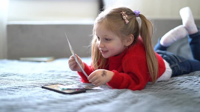 little blonde girl with a smartphone counts money