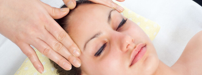 Fototapeta na wymiar Young women getting a face massage in massage salon