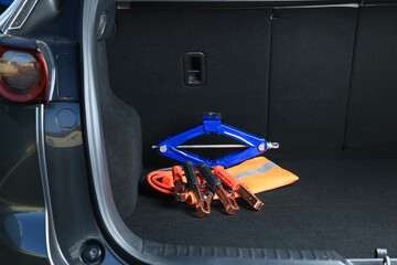 Naklejka premium Scissor jack, life vest and battery jumper cables in trunk. Car safety equipment