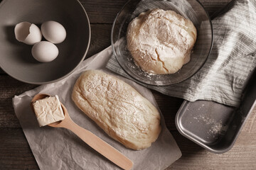 Raw dough, eggs and flour on wooden table, flat lay. Cooking ciabatta