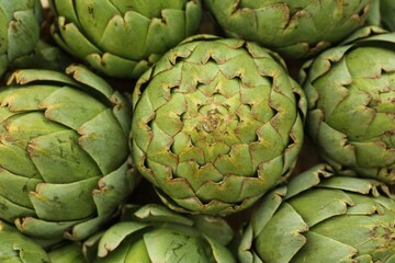 Obraz premium Many fresh raw artichokes as background, top view