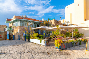 A colorful cafe with outdoor seating in Kedumim Square (Kikar Kdumim), in the medieval Ottoman era...