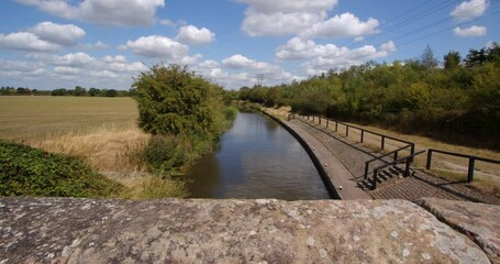 Wide shot from Aston Lock looking down on to Trent and Mersey Canal with stone bridge walls in foreground