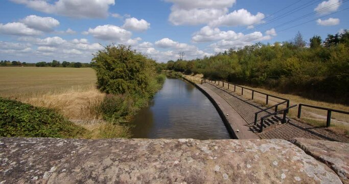 Wide shot from Aston Lock looking down on to Trent and Mersey Canal with stone bridge walls in foreground