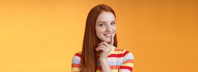 Curious devious redhead young 20s girlfriend have excellent idea smirking tricky touch lip flirty mysteriously glancing camera have plans preparing interesting surprise, standing orange background