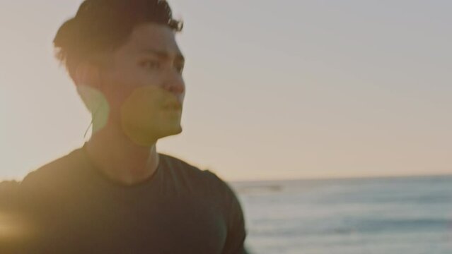 Running, music and beach of man in fitness training for speed, energy and competition with wellness, podcast or mental health audio. Earphones, sea and sports runner with exercise, cardio or workout