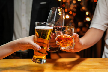 food and drink male friends are happy drinking beer and clinking glasses at a bar or pub.