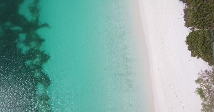 Aerial top view Tropical green-blue waters lap onto dazzlingly white sand beaches and beneath enchanting coast