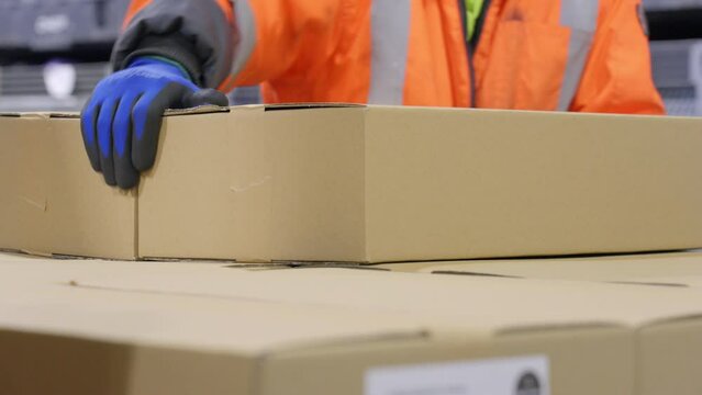 4K Close Up Of Warehouse Worker Stacking Cardboard Boxes By Hand