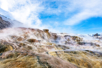Mammoth Hot Springs Terraces with steam in white and yellow, along with sky and cloud as background