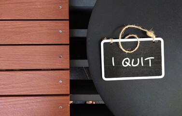 Chalkboard on coffee table with text handwritten I QUIT, concept of decision making to stop (behaviors doing something) or leave (place) permanently, job relationship marriage or bad habits