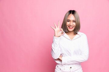 Happy Asian portrait beautiful cute young woman excited gesturing ok sign, studio shot isolated on pink background.