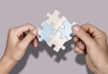 Business persons hands holding puzzle pieces