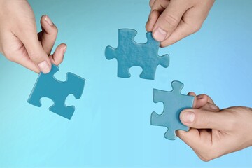 Business persons hands holding puzzle pieces