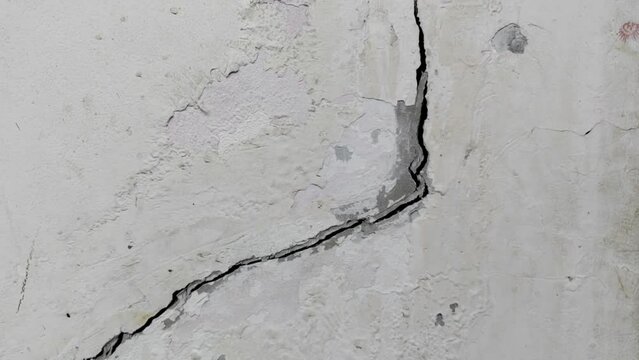 Cracked concrete ground broken at old wall from bad construction or earthquake