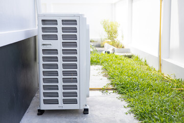 Side view of an air conditioner cooler installed on the exterior floor of a building or house.