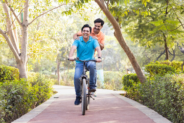 Two friends cyclist having fun riding bicycle outdoors on countryside road
