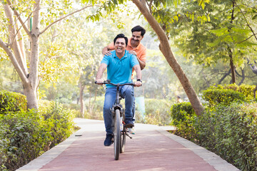 Obraz premium Two friends cyclist having fun riding bicycle outdoors on countryside road