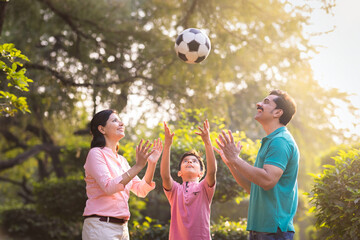 Happy indian family playing with football at park