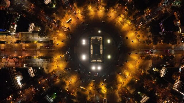 Drone films the Arc de Triomphe statically from above, top shot, many cars drive in circles around the Arc de Triomphe in Paris