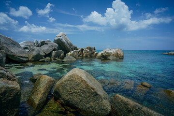Fototapeta na wymiar rocks on the beach at dream island when blue sky and cloud
