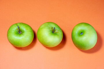 Fresh ripe juicy green apple fruit on orange background