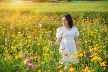 Portrait of asian Young woman happy traveler with white dress enjoying in Yellow and pink sulfur Cosmos flowers blooming field in the nature garden of in Chiang Mai,Thailand,travel relax vacation