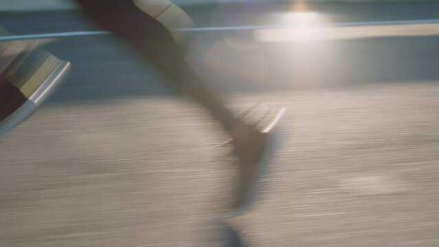 Running, feet and asphalt road for athlete with sport shoes for speed, fast and agile cardio training outdoor in summer for marathon, sprint or race challenge. Legs of woman runner on path to fitness
